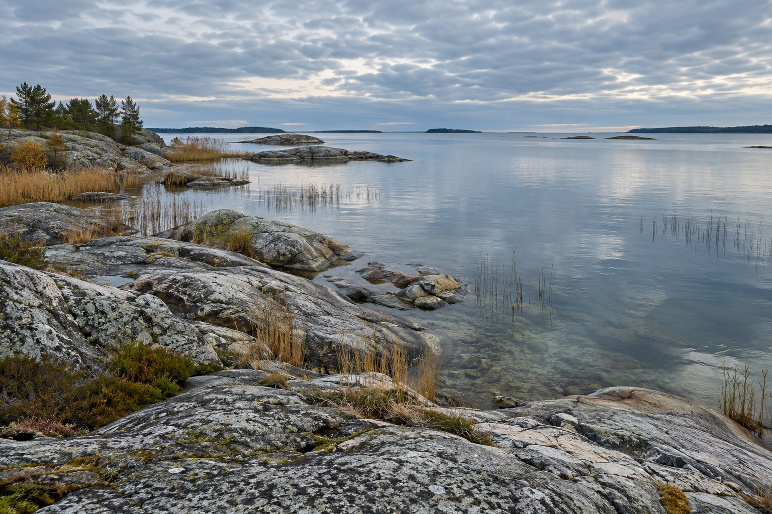 Rounded pale granite rocks beside quiet Baltic water